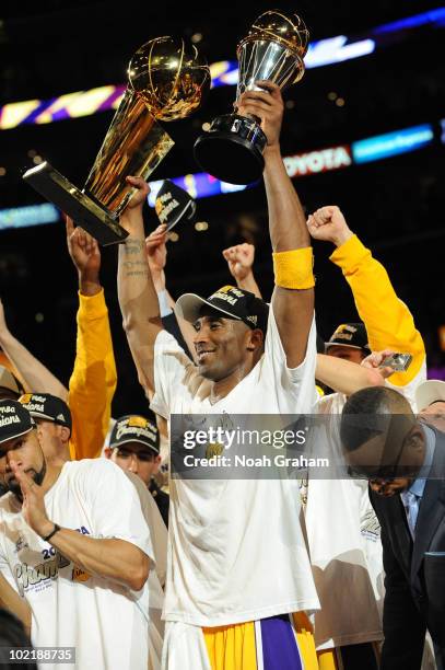 Kobe Bryant of the Los Angeles Lakers hoists the Larry O'Brien Trophy and the Bill Russell MVP trophy following his team's victory over the Boston...