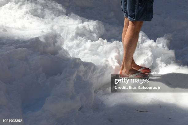 man walks on snow in shorts and flip-flops, cold weather - shorts stock pictures, royalty-free photos & images