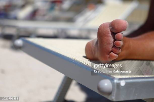 foot of man lying on beach bed - salento foto e immagini stock