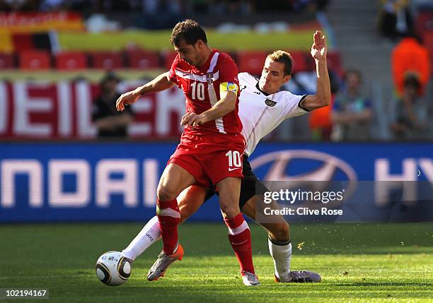 Miroslav Klose of Germany tackles Dejan Stankovic of Serbia during the 2010 FIFA World Cup South Africa Group D match between Germany and Serbia at...