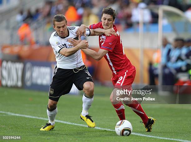 Lukas Podolski of Germany tussles with Zdravko Kuzmanovic of Serbia during the 2010 FIFA World Cup South Africa Group D match between Germany and...