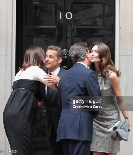 French President Nicolas Sarkozy and his wife Carla Bruni-Sarkozy are kissed goodbye by Prime Minister David Cameron and his wife Samantha on the...