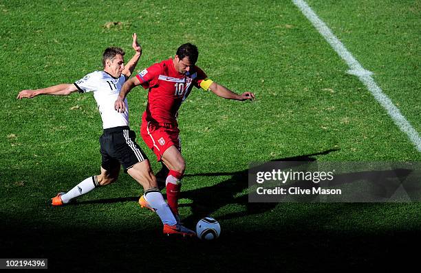 Miroslav Klose of Germany tackles Dejan Stankovic of Serbia and then receives a second yellow card and is sent off during the 2010 FIFA World Cup...