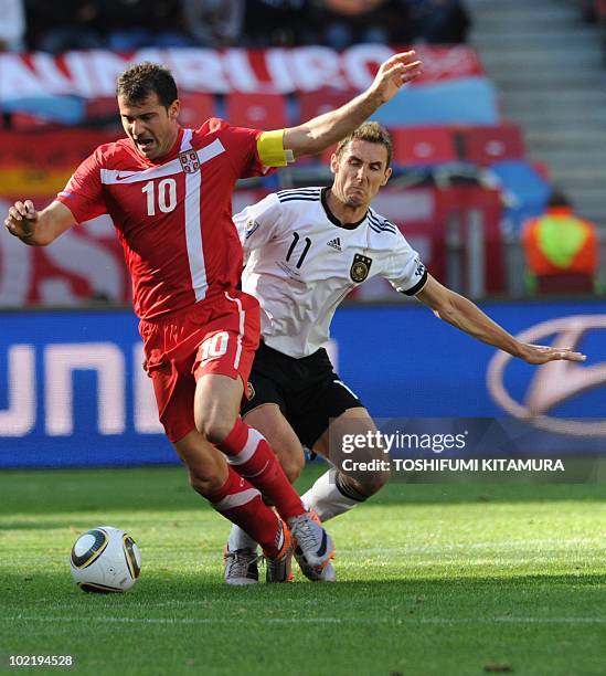 Serbia's midfielder Dejan Stankovic is challenged for the ball by Germany's striker Miroslav Klose during the Group D first round 2010 World Cup...