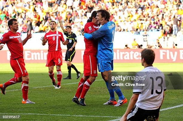 Goalkeeper Vladimir Stojkovic of Serbia celebrates with team mates after he saved a penalty as Thomas Mueller of Germany looks on during the 2010...