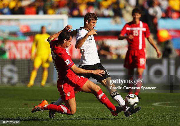Dejan Stankovic of Serbia tackles Thomas Mueller of Germany during the 2010 FIFA World Cup South Africa Group D match between Germany and Serbia at...