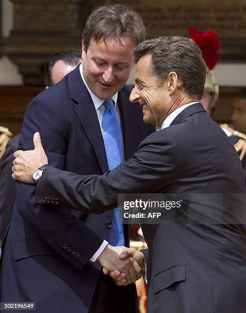 Britain's Prime Minister David Cameron embraces French President Nicolas Sarkozy in between speeches at The Royal Hospital Chelsea in London June 18,...