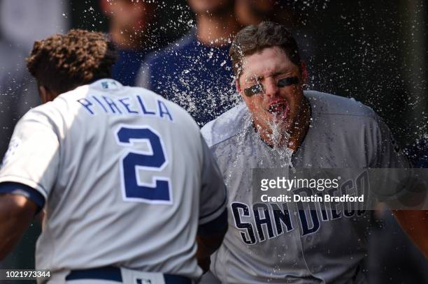 Hunter Renfroe of the San Diego Padres celebrates in the dugout as Jose Pirela splashes him in the face with water after hitting a sixth inning solo...