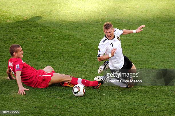 Nemanja Vidic of Serbia tackles Bastian Schweinsteiger of Germany during the 2010 FIFA World Cup South Africa Group D match between Germany and...