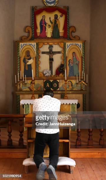 man kneeling and praying in new mexican church - altare stock pictures, royalty-free photos & images