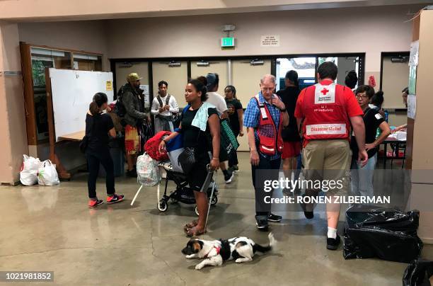 Peopleenter a Red Cross shelter at McKinley High School ahead of the arrival of hurricane Lane in Honolulu, Hawaii on August 23, 2018. - Hurricane...