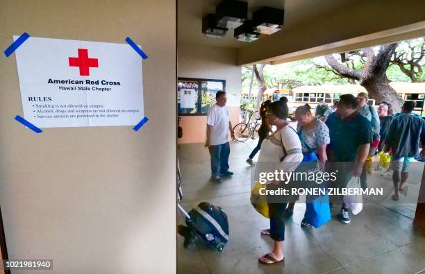 People enter a Red Cross shelter at McKinley High School ahead of the arrival of hurricane Lane in Honolulu, Hawaii on August 23, 2018. - Hurricane...