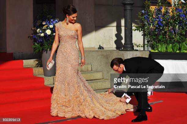 Princess Victoria is helped with her dress by fiance Daniel Westling during the Government Pre-Wedding Dinner for Crown Princess Victoria of Sweden...