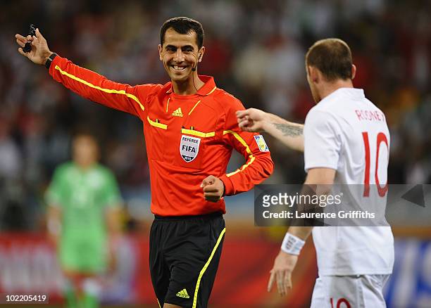 Referee Ravshan Irmatov smiles at Wayne Rooney of England during the 2010 FIFA World Cup South Africa Group C match between England and Algeria at...