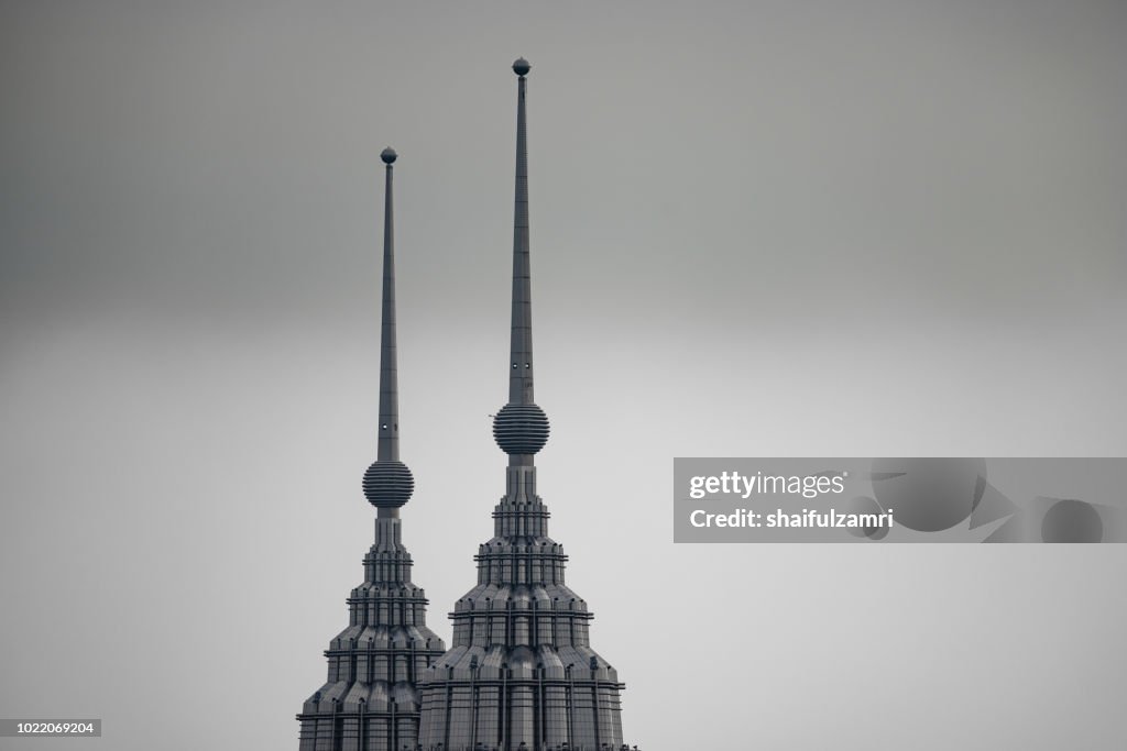 Peak of Petronas Twin Towers over cloudy and hazy day in Kuala Lumpur, Malaysia.