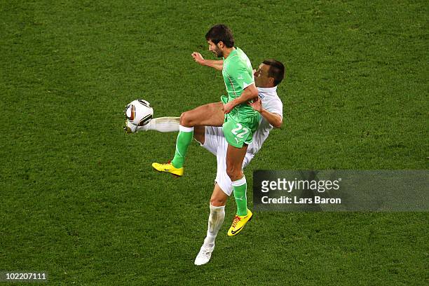John Terry of England and Djamal Abdoun of Algeria jump for the ball during the 2010 FIFA World Cup South Africa Group C match between England and...