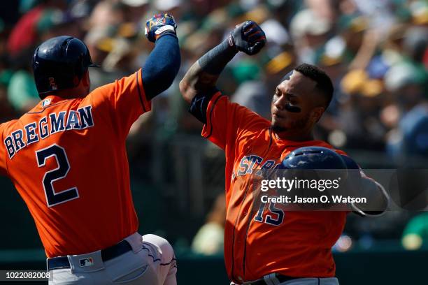 Martin Maldonado of the Houston Astros is congratulated by Alex Bregman after hitting a home run against the Oakland Athletics during the seventh...