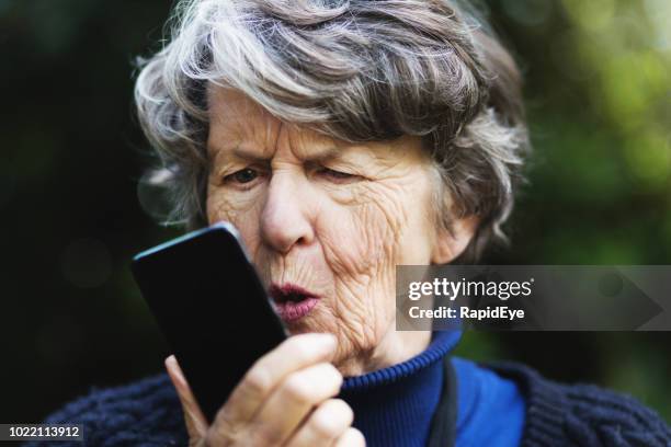 furious or frustrated senior woman shouts into mobile phone - shouting phone stock pictures, royalty-free photos & images