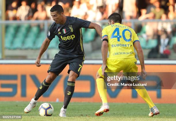 Cristiano Ronaldo of Juventus FC is challenged by Nenad Tomovic of Chievo Verona during the serie A match between Chievo Verona and Juventus at...