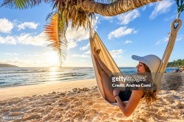 a beautiful woman on a tropical beach, sleeps in a hammock - woman hammock photos et images de collection