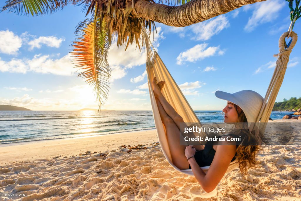 A beautiful woman on a tropical beach, sleeps in a hammock