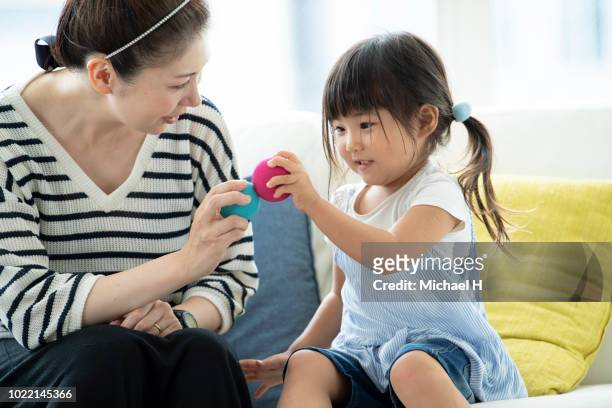 mother playing with a daughter with a ball - ball chair foto e immagini stock