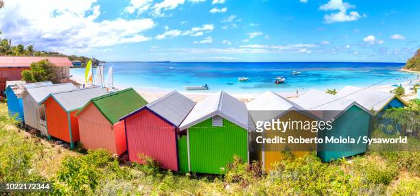 panoramic of multi colored beach huts seafront, long bay, antigua, - antigua leeward islands stock-fotos und bilder