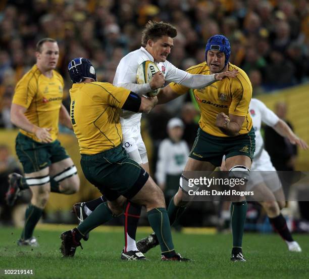 Toby Flood of England is held by Nathan Sharpe and Ben Daley during the Cook Cup Test Match between the Australian Wallabies and England at ANZ...