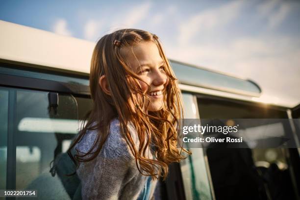 happy girl looking out of window of an off-road vehicle - one girl stock-fotos und bilder