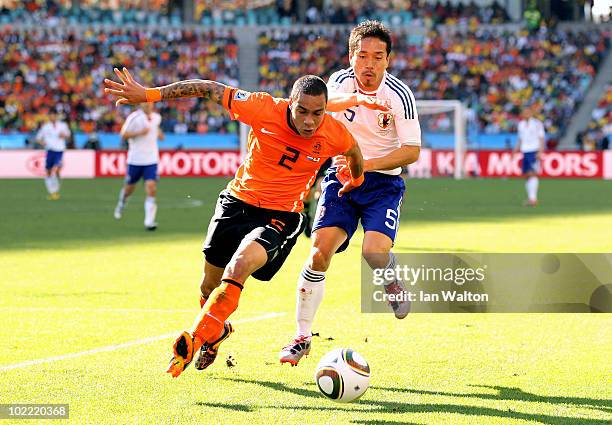 Gregory Van Der Wiel of the Netherlands is challenged by Yuto Nagatomo of Japan during the 2010 FIFA World Cup South Africa Group E match between...