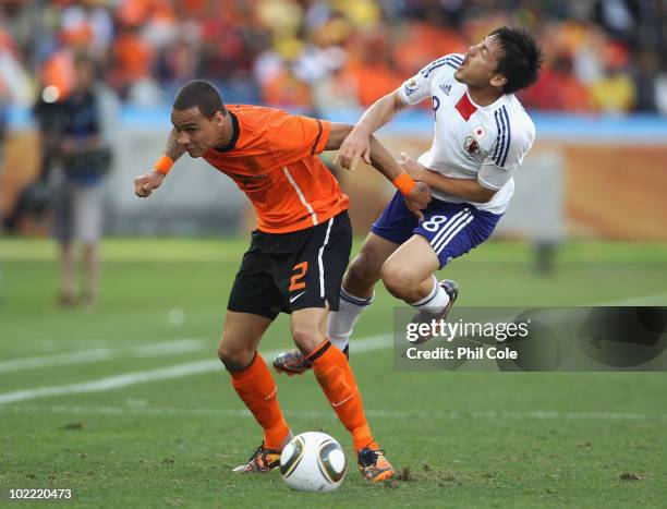 Gregory Van Der Wiel of the Netherlands clashes with Daisuke Matsui of Japan during the 2010 FIFA World Cup South Africa Group E match between...