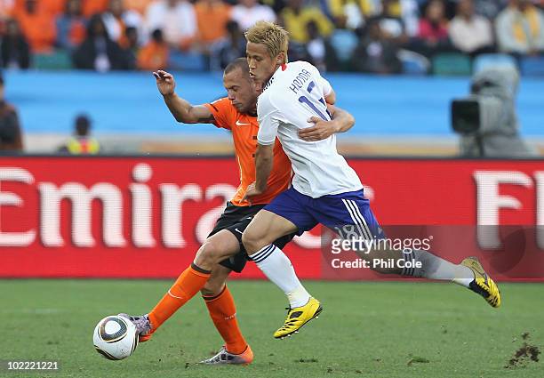 John Heitinga of the Netherlands and Keisuke Honda of Japan tussle for the ball during the 2010 FIFA World Cup South Africa Group E match between...