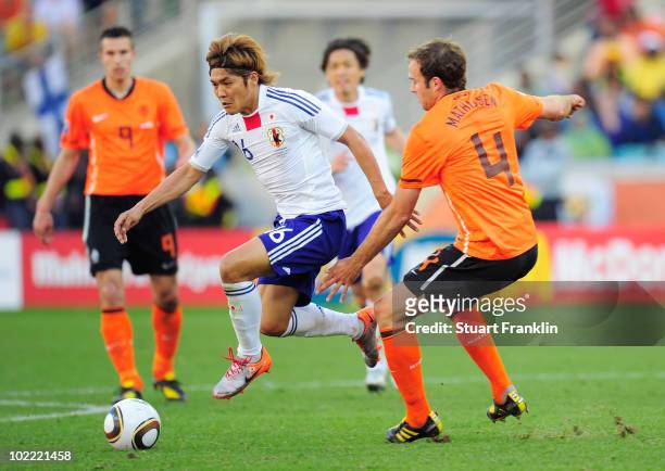 Yoshito Okubo of Japan skips the challeneg of Joris Mathijsen of the Netherlands during the 2010 FIFA World Cup South Africa Group E match between...