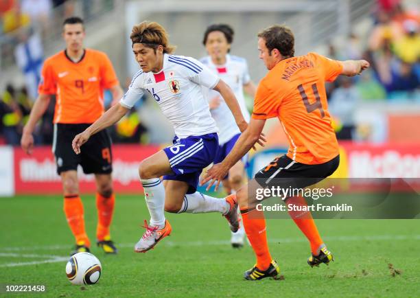 Yoshito Okubo of Japan skips the challeneg of Joris Mathijsen of the Netherlands during the 2010 FIFA World Cup South Africa Group E match between...