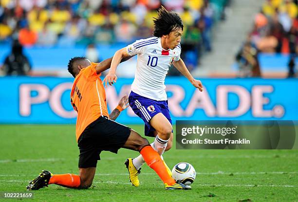 Eljero Elia of the Netherlands tackles Shunsuke Nakamura of Japan during the 2010 FIFA World Cup South Africa Group E match between Netherlands and...