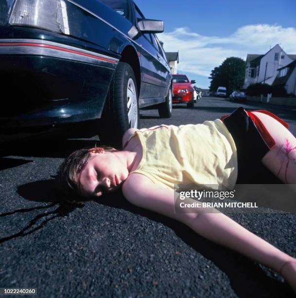 young girl knocked down by a car and lying on the road - gory car accident fotos stock-fotos und bilder