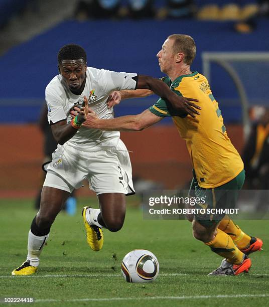 Ghana's striker Asamoah Gyan fights for the ball with Australia's defender Craig Moore during the Group D first round 2010 World Cup football match...