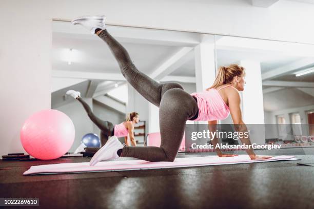 mujer hermosa haciendo a pilates estiramiento ejercicios en gimnasio - womens bottoms fotografías e imágenes de stock