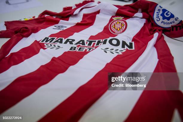 The sponsor logo of Marathonbet Spain, SA sits on the chest of the new 2018-2019 jersey design of Girona FC as it is displayed at Estadi Montilivi,...