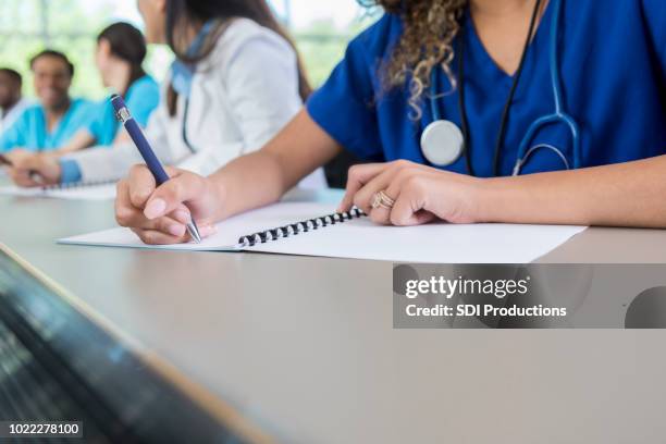 unrecognizable medical student writes in class workbook - workbook stock pictures, royalty-free photos & images