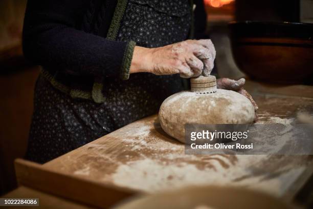 close-up of historical baker woman stamping a raw bread - artisan food stock-fotos und bilder