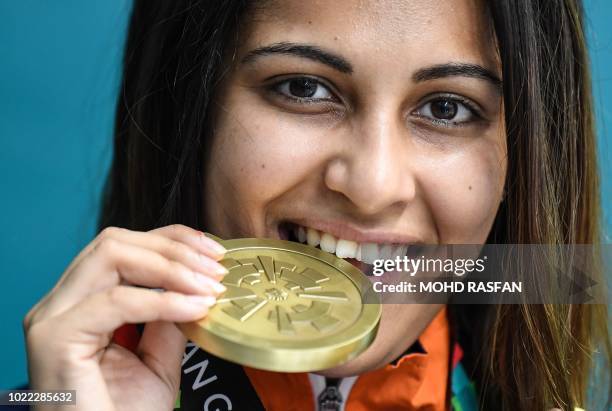 Bronze medallist India's Heena Sidhu poses with her medal during the victory ceremony for the women's 10m air pistol shooting at the 2018 Asian Games...