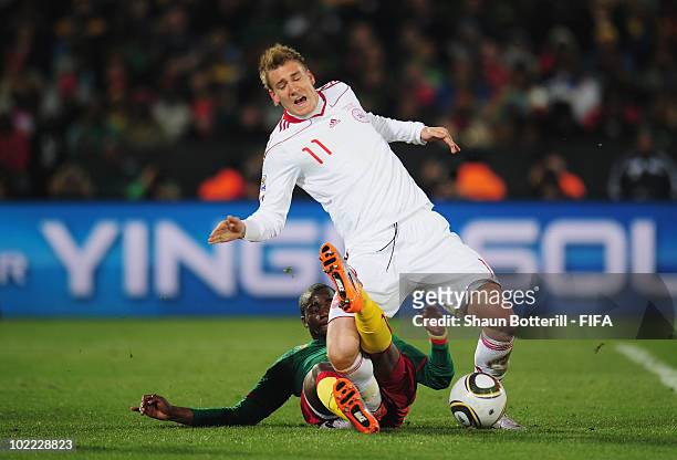 Sebastien Bassong of Cameroon tackles Nicklas Bendtner of Denmark during the 2010 FIFA World Cup South Africa Group E match between Cameroon and...