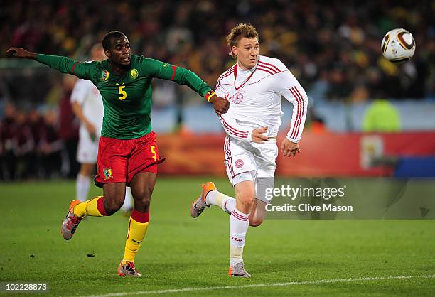 Sebastien Bassong of Cameroon challenges Nicklas Bendtner of Denmark during the 2010 FIFA World Cup South Africa Group E match between Cameroon and...