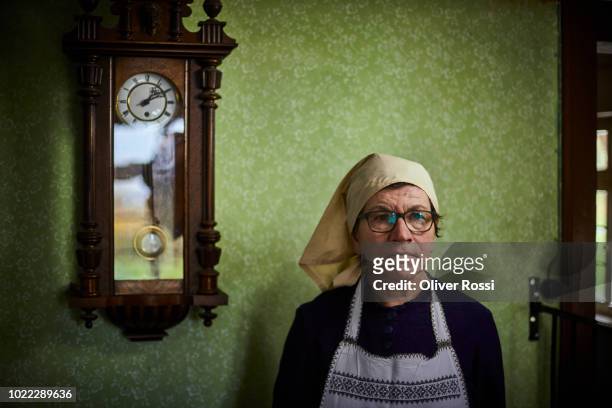 portrait of pensive senior woman at old-fashioned wall clock - memory and human rights museum stock pictures, royalty-free photos & images