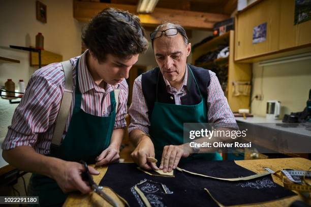 old and young tailor in workshop making bavarian lederhosen - strict parent imagens e fotografias de stock