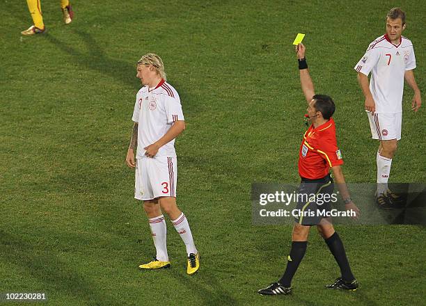 Simon Kjaer of Denmark is shown a yellow card by referee Jorge Larrionda during the 2010 FIFA World Cup South Africa Group E match between Cameroon...