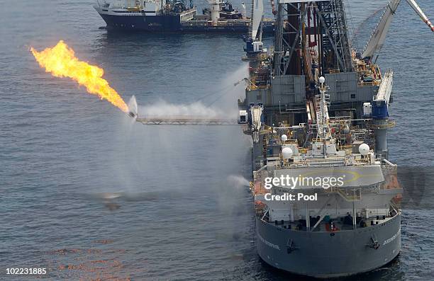 The Discoverer Enterprise burns off gas as it collects oil at the site of the Deepwater Horizon oil spill on June 19, 2010 in the Gulf of Mexico off...