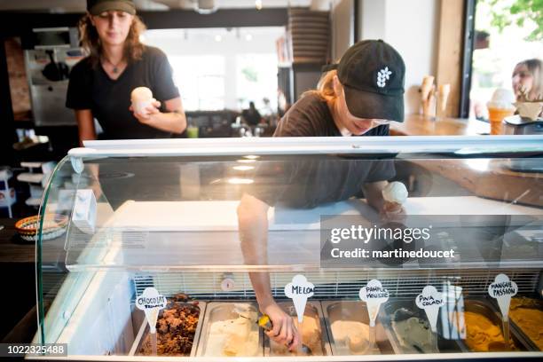customer service in artisanal ice cream parlor. - ice cream parlour stock pictures, royalty-free photos & images