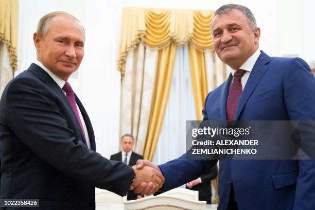 Russian President Vladimir Putin and Anatoly Bibilov, the leader of Georgia's breakaway region of South Ossetia shake hands prior to their meeting in...